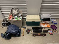 Overview of assorted items including cooler, tools, toaster, clock, and bins