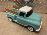 Side view of the ceramic light blue and white Chevy 3100 truck with brown wooden side rails.