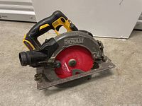 Full view of Dewalt cordless circular saw showing red blade, body, and handle.