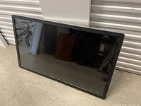 Front view of monitor lying on floor, showing full display and bezel