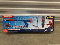 Front view of the sealed box showing the Huffy Spider-Man Electrolight scooter, depicting the scooter images and branding.