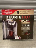Front of sealed Keurig K Cup 2.0 K545 Plus Series coffee maker box showing product image and specs.