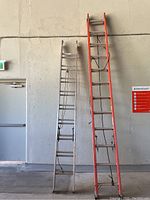 Two extension ladders leaning against a wall, showing relative heights