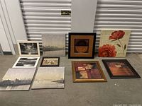 Full view of all art pieces laid on floor showing variety of prints and frames including cityscapes, abstract and floral.
