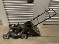 Side angle showing entire Craftsman gas-powered lawn mower with grass catcher bag attached.