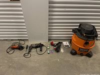 Full lot view showing power tools and shop vac lined up on floor