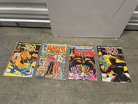 Four vintage Marvel comic books laid out on floor including Star Trek, Black Panther, and Stan Lee titles