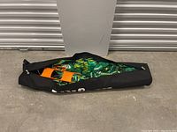 Black carry bag closed with contents inside, showing the net and poles packed inside.