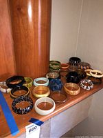 Image showing 18 costume jewelry bracelets on a wood surface displaying variety in color and style.