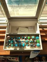 Overview of the beige jewelry box with clear lid displaying all rings