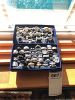 Two-tier velvet tray filled with rows of silver-tone costume rings