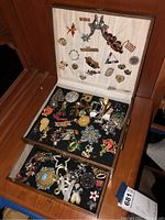 Wooden two-shelf box open showing lid pins and two layers of jewelry