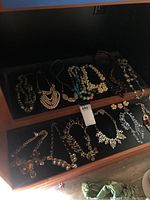 Wide shot of multiple costume jewelry necklaces in display case with various designs and beads