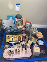Full view of assortment of vintage perfume bottles, boxed perfumes, and related cosmetic items on a table.
