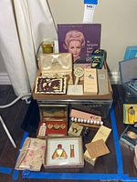Overview of assorted vintage perfume bottles and sets on floor