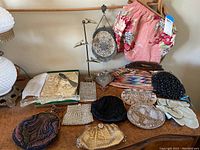 Overall view of the assortment displayed on a table showing purses, coin purses, gloves, and hat pins.