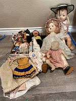 Overview of dolls and doll clothes showing a variety of dolls and clothing items.