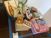 Wide view of various vintage perfume bottles, boxes, and fabric sachets arranged on floor