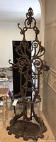Front view of wrought iron hat tree showing overall scrollwork design and base