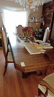Full view of double pedestal dining table with leaf inserted and six chairs around it