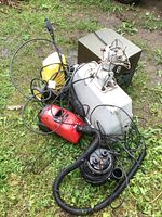 Photo of all items scattered on the ground showing vacuum, pressure washer, submersible pump, and outdoor light fixture with wired deer frame.