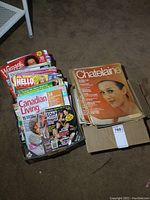 Box filled with assorted vintage magazines including Woman's Day, Hello, Canadian Living and Soap Opera Digest, showing moderate wear and color fading on covers.