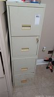 Front view of a beige metal 2-drawer file cabinet with visible moisture damage and stains on bottom drawer.