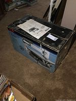 Original box of Ryobi 16" scroll saw with label and picture of saw on the box in worn condition.