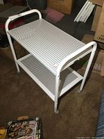 Multichef electric warming cart, white metal, top and side view showing ventilated warming surface and lower storage shelf