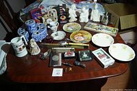 Full view of various ceramics, plates, kitchen and decorative items arranged on a table.