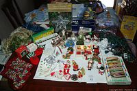 Full overview of Christmas decorations laid out on table including stockings, string lights, garlands, and assorted ornaments.