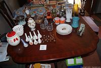Lot displayed on a wooden table showing a variety of kitchenware, ceramics and decorative items.