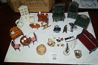 Wide view of the entire miniature furniture and accessory set arranged on a white cloth.