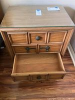 Front view of the Drexel nightstand with one drawer open, showing interior wooden finish and metal drawer pulls.