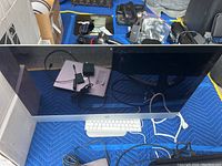 Front view of iMac display and wired keyboard on moving blanket