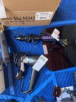 Two CHI Rocket hair dryers and a black digital scale with cords, on blue padded surface.