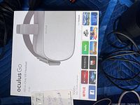 White Oculus Go All-in-One VR Headset 32GB retail box with app logos and power cable visible