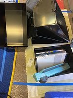 Lot including the GBC binding machine with PVC covers in black box, metal storage container, and other office supplies.