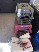 Two stacked plastic pet cages with metal doors, pet bedding, and assorted accessories.