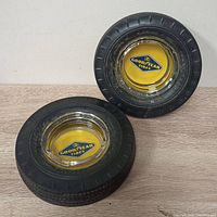 Two Goodyear tire ashtrays made from rubber tractor tires with clear glass centers.