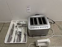 Photo showing the Breville 4-slot toaster, a white ToastMaster hand mixer without beaters, and a tray with assorted Venu hammered finish silverware including knives, forks, and spoons.