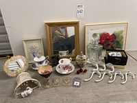 Wide view of the lot including mirrors, tea cups, decanter, decorative bowl, coat hooks, bottle openers, lampshade nightlight, and small decorative items