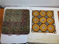 Two square pillow covers: green-beige floral border and mustard/black concentric circles