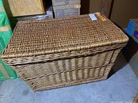 Top angle of a large rectangular wicker trunk with a removable lid, showing the woven pattern and lid fitting.