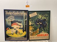 Pair of framed German posters hanging on wall, showing full view of both artworks and frames.