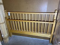 Headboard and footboard showing vertical slat design with rounded finials on posts.