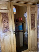 Front view showing wardrobe central beveled glass door, and carved wooden side doors