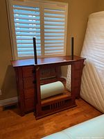 Dresser frame upside down with detached mirror leaning against it in front of window blinds