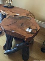 Full view of the wooden slab table top with epoxy coating and natural tree branch legs.