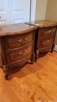 Photo of the two matching wooden night stands side by side showing full height, drawers, and legs.